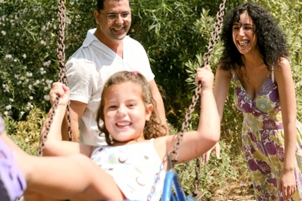 Girl on swings with parents